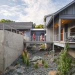 Exterior of new house showing kids on elevated bridge between garage and house