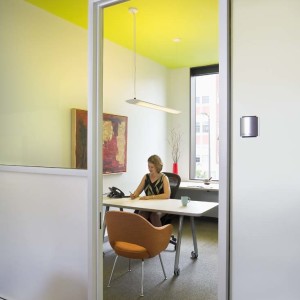 Woman sits at desk in modern colorful office