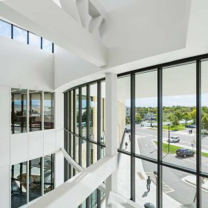 View out large wall of curving windows from atrium of new university building