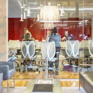 People having a meeting in a coloful conference room behind glass windows