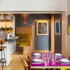 Arched doorway to restaurant with chef working in open kitchen