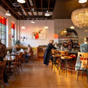 A warm cozy restaurant with patrons eating and drinking