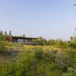 Angled shot of Burnt Rock cabin late afternoon with surrounding vegetation