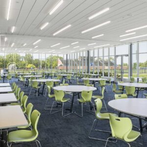 School lunchroom with floor to ceiling windows looking out to athletic field