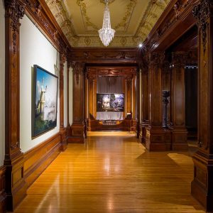 Ornate music room in the American Swedish Institute showing photographs by Erik Johansson