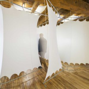 Man entering stretched white spandex pod on metal frame that creates a flexible work space in a chiropractic office