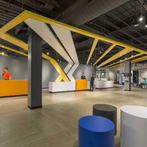Large front desk area of Xperience Fitness with people at desk
